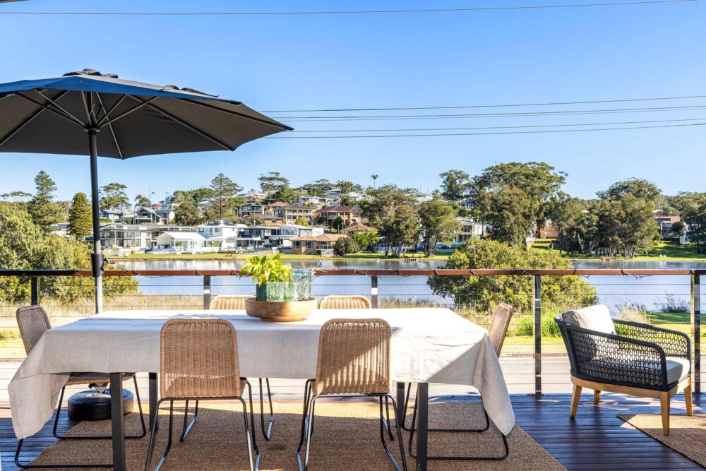 A rare lakefront position in Wamberal's Golden Triangle, an easy five-minute walk to Terrigal Beach and its café strip. This 5-bedroom, 3-bathroom home sleeps up to 10 guests across two thoughtfully separated levels, with sweeping water views, a signature glass floor, two private view decks, and a fifth bedroom with its own ensuite on a private level. Air-conditioned throughout with Wi-Fi and Smart TVs. Minutes from Terrigal Golf Club, the Skillion Lookout walk, and a well-known dive site. Ideal for multi-family holidays, milestone celebrations, and groups who want space, water views, and the beach on their doorstep.